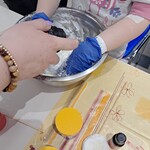 Ręce dziecka w rękawiczkach zagniatającego w misce slime.