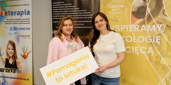 Nauczycielki trzymają napis Pomaganie to sztuka