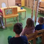 Nauczycielka przedstawia  legendę zgromadzonym w świetlicy kliniki nefrologii dzieciom