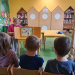 Dzieci oglądają kolejne plansze prezentowane przez nauczycielkę z teatrzyku.