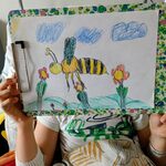 Uczeń pokazuje skończoną pracę - Lecąca nad kwiatkami pszczoła