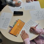 dzieci przy stole rozwiązują łamigłówki