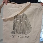 chłopiec pokazuje swoją torbą z kotem