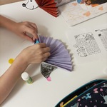 dziecko wykonuje jeża w technice origami z wachlarza