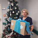 pielęgniarka przy choince trzyma pudełko z ozdobami