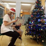 pani Marta pokazuje chłopcu planszę przy choince