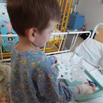 Chłopiec trzyma wyciętą z papieru śnieżynkę