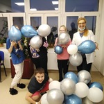 Nauczycielka i dzieci prezentują balony z definicjami szczęścia