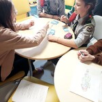 harcerki grają z pacjentkami szpitala w uno przy stole