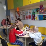Dzieci wykonują prace plastyczne w świetlicy kliniki neurologii.