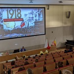 Katechetka Pani Anna Białous zachęca uczestników apelu do wspólnego wykonywania pieśni patriotycznych.