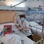 Nauczyciel w czapce tygryska prezentuje dziecku książki o dzikich zwierzętach