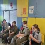 harcerze siedzą na krzesłach w świetlicy Kliniki Neurologii
