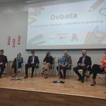 uczestnicy konferencji siedzą w półokręgu podczas debaty