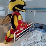 maskotka jagiellonii stoi przy łóżku pacjenta