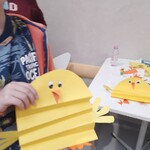 chłopiec trzyma wykonanego z papieru kurczaka