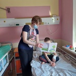 Nauczyciel ubrany w kamizelkę edukacyjną - Ciało człowieka, czyta dziecku - Jak dbać o zdrowie