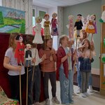Aktorzy z przedszkola wraz z wychowawczynią prezentują kukiełki