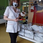 Nauczyciel przebrany za misia z pacynką liskiem przy łóżku dziecka