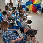 Dzieci - pacjenci oddziału szpitalnego i ich mamy grają na instrumentach muzycznych