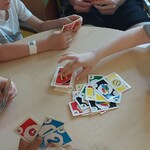 dzieci grają w uno z harcerzami przy stoliku