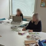 dziewczyny układają przy stole puzzle