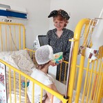 Dziecko słucha treści książki o króliku czytanej przez nauczycielkę w przebraniu za głównego bohatera