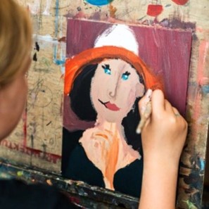kobieta maluje portret na płótnie