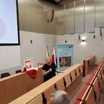 Aula, dyrektor szkoły z mikrofonem stoi przez widownią