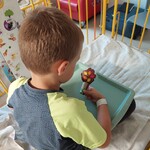 Dziecko trzyma w dłoni jesienne drzewo wykonane przez siebie z materiałów papierniczych