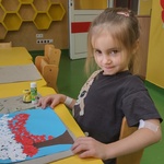 Dziewczynka wykonuje pracę plastyczną- drzewko w barwach narodowych.