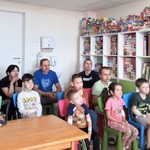 Świetlica szpitalna wypełniona widzami siedzącymi na krzesełkach.