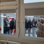 pozdrawiający przez okno  wolontariusze ze Szkoły Branżowej oraz Białostockiej Szkoły Nowej Ewangelizacji, którzy przygotowali małym pacjentom świąteczne prezenty.