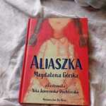 na białym materiale leży książka pt. Aliaszka Magdaleny Górskiej