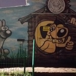 ściana budynku z namalowanym logo schroniska z psami budą dla psa i napisem czekam