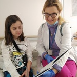 nauczycielka pokazuje książkę siedzącej obok niej dziewczynce