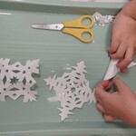 Dziecko składa papier według instrukcji nauczyciela